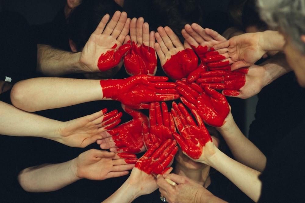 Balck background with support and positive 'social Circle of Friends with hands together and with painted red hand showing togetherness