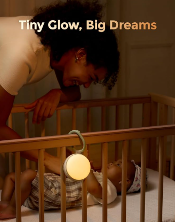 Showing mother calming baby in cot with the Momcozy Portable Sound machine set up